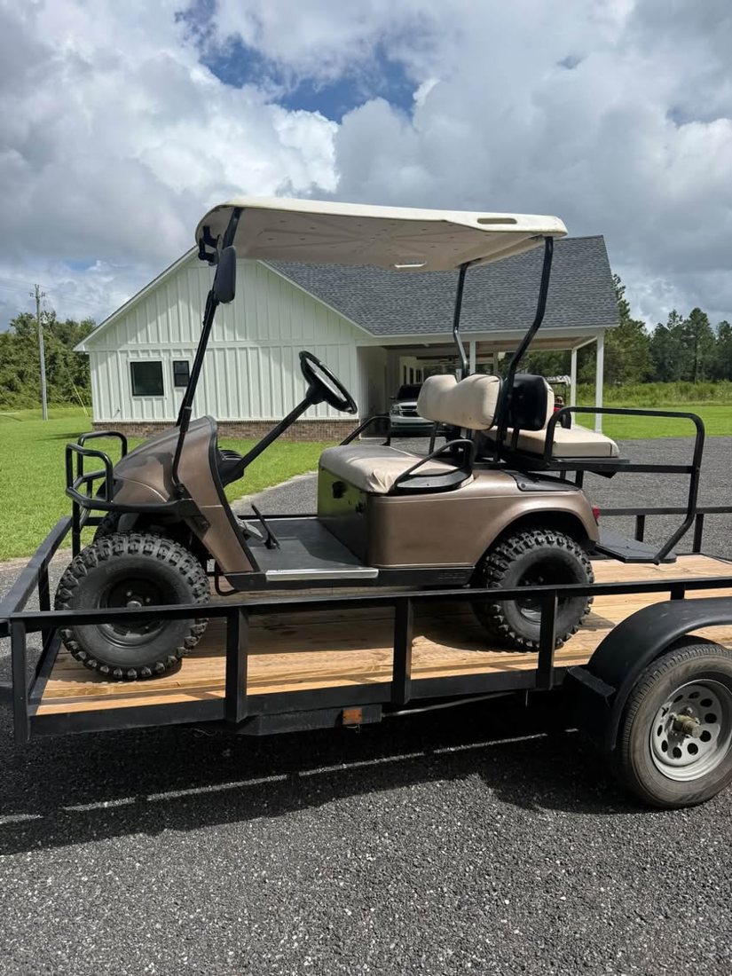 Bronze gas EZGO on a trailer after repair