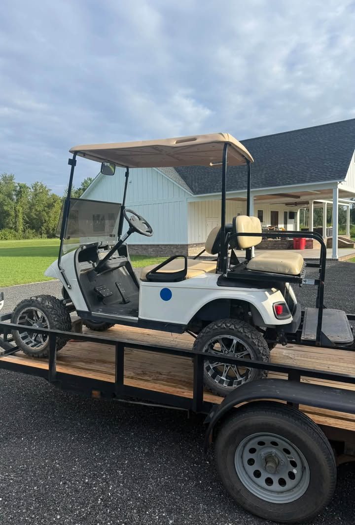 White gas EZGO on a trailer after repair